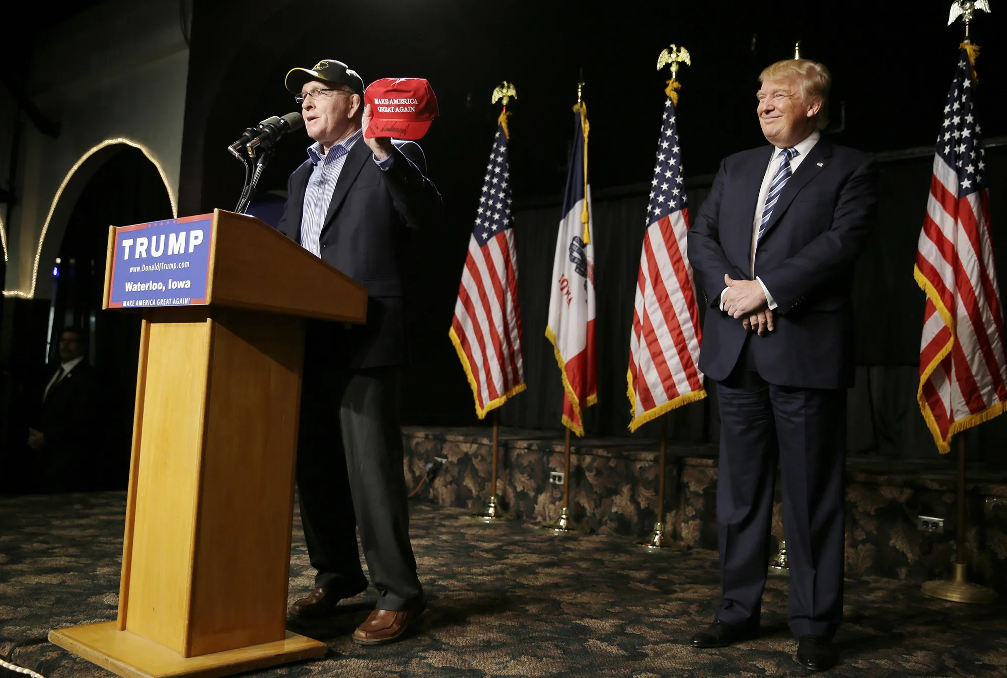 Donald Trump listens as Dan Gable speaks during a campaign stop in Waterloo, Iowa in 2015.