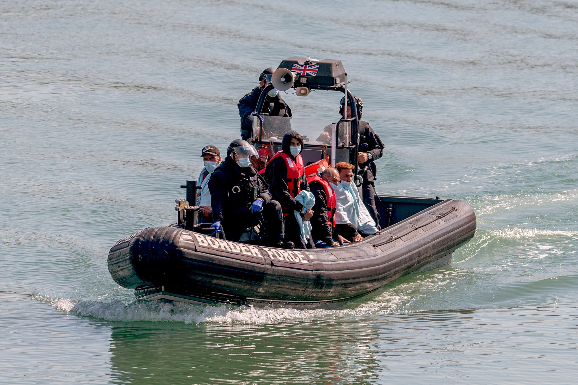 UK border force officers escort&nbsp;migrants to Dover Docks in Dover, UK, on June 16.