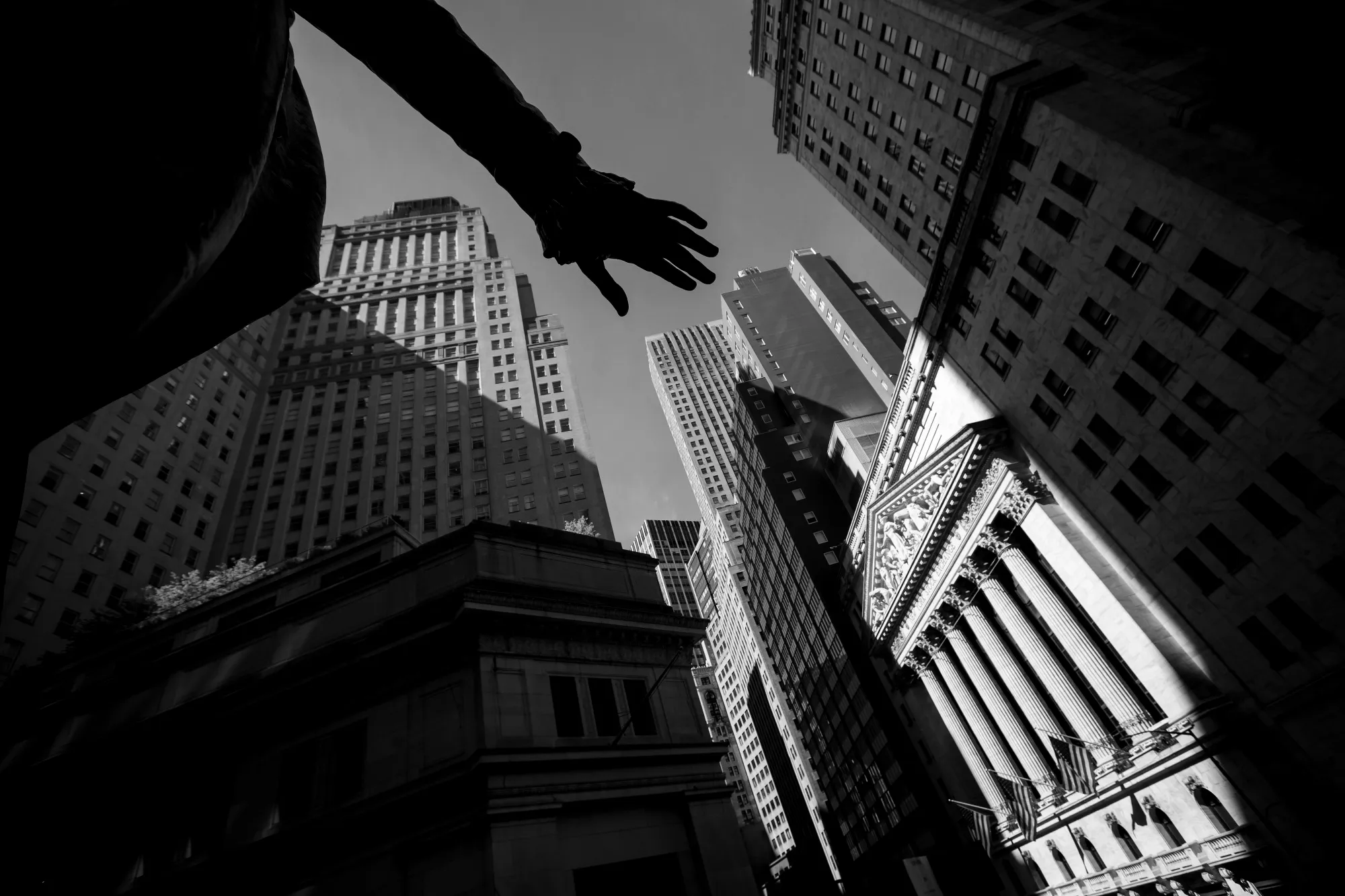 The hand of the George Washington statue at Federal Hall hovers above the New York Stock Exchange.