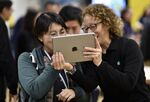 People interact with an Apple iPad in Chicago.