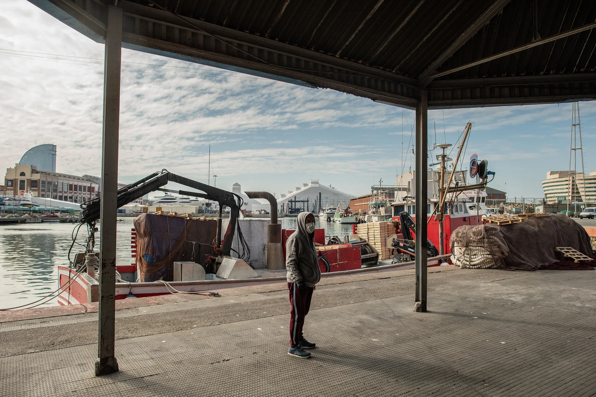 A visitor pauses in the quiet fishing port at the Port of Barcelona in March.