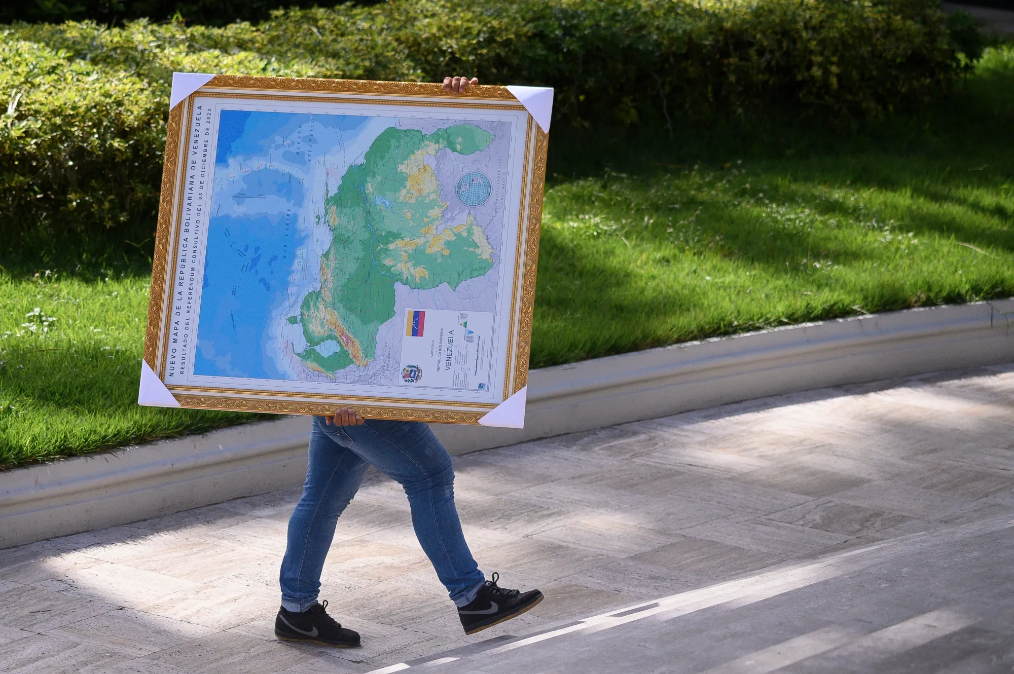 A National Assembly worker carries a map with the territory of Essequibo marked as a Venezuelan state in Caracas.