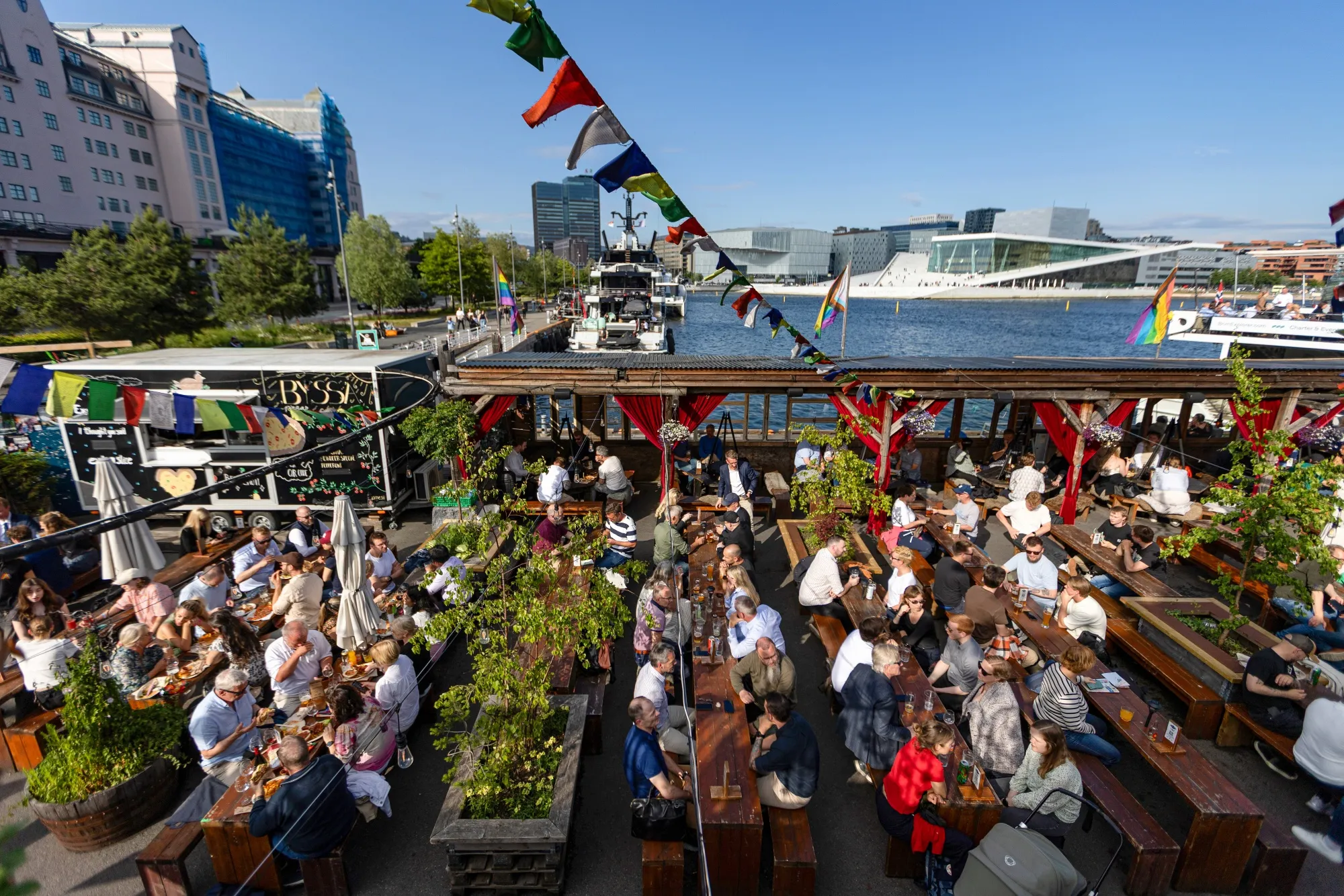 Customers at a waterside restaurant terrace in Oslo.
