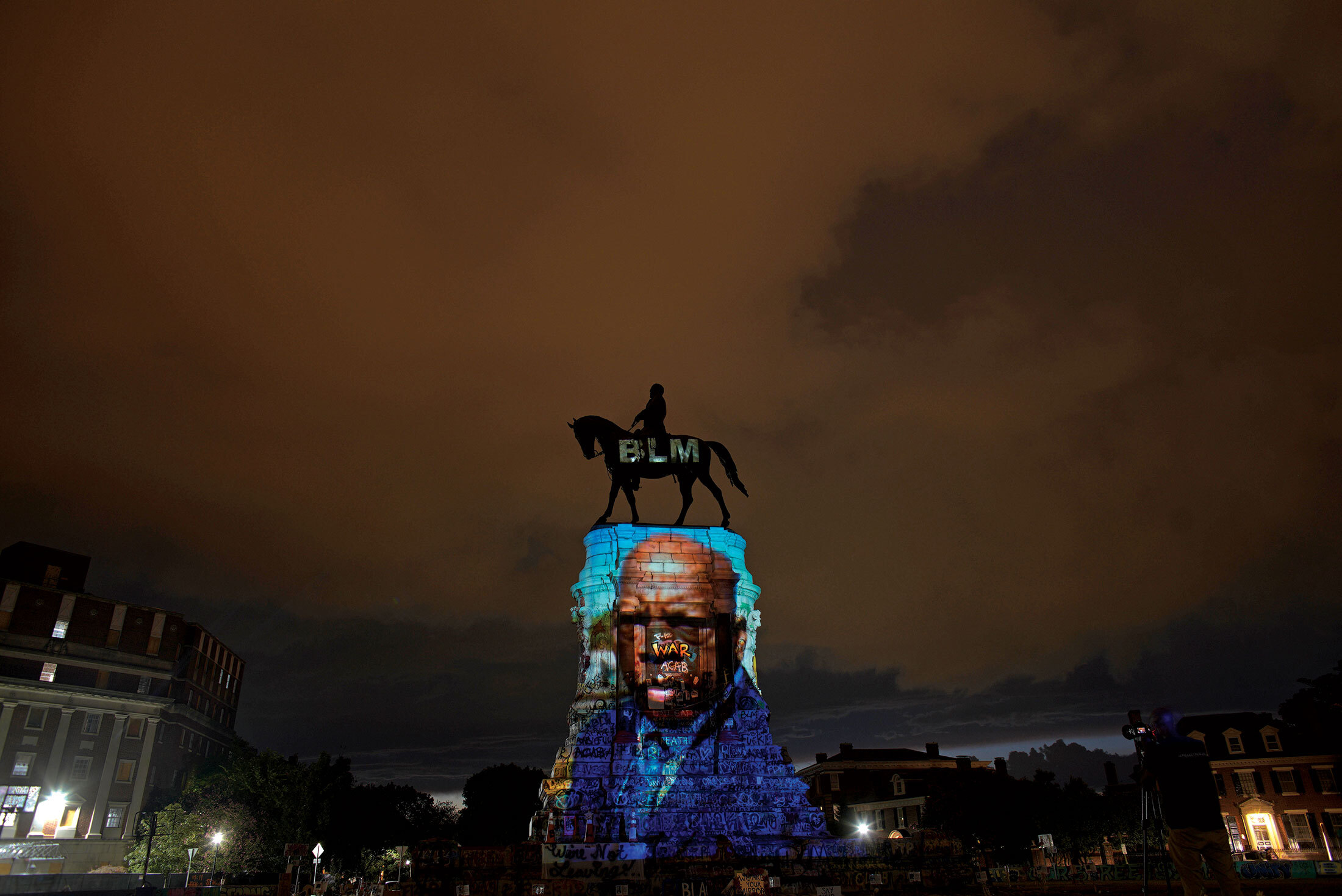 Artist Dustin Klein projected an image of Representative John Lewis—the legendary civil rights leader who died on July 17—onto the Robert E. Lee Monument in Richmond on July 24.