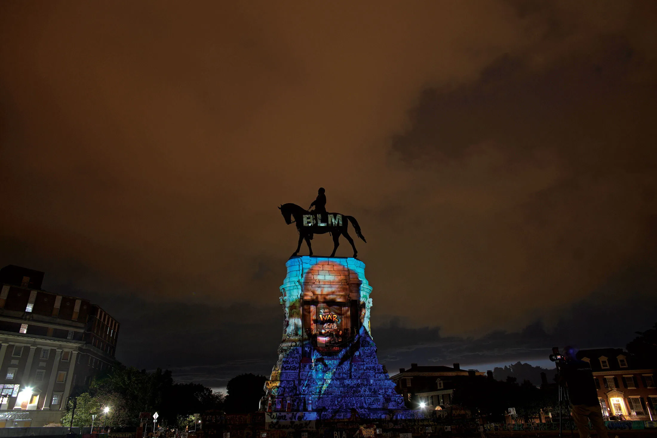 Artist Dustin Klein projected an image of Representative John Lewis—the legendary civil rights leader who died on July 17—onto the Robert E. Lee Monument in Richmond on July 24.