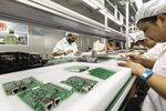Employees on a production line at a Smart Pioneer Electronics Co. factory in Suzhou, China.