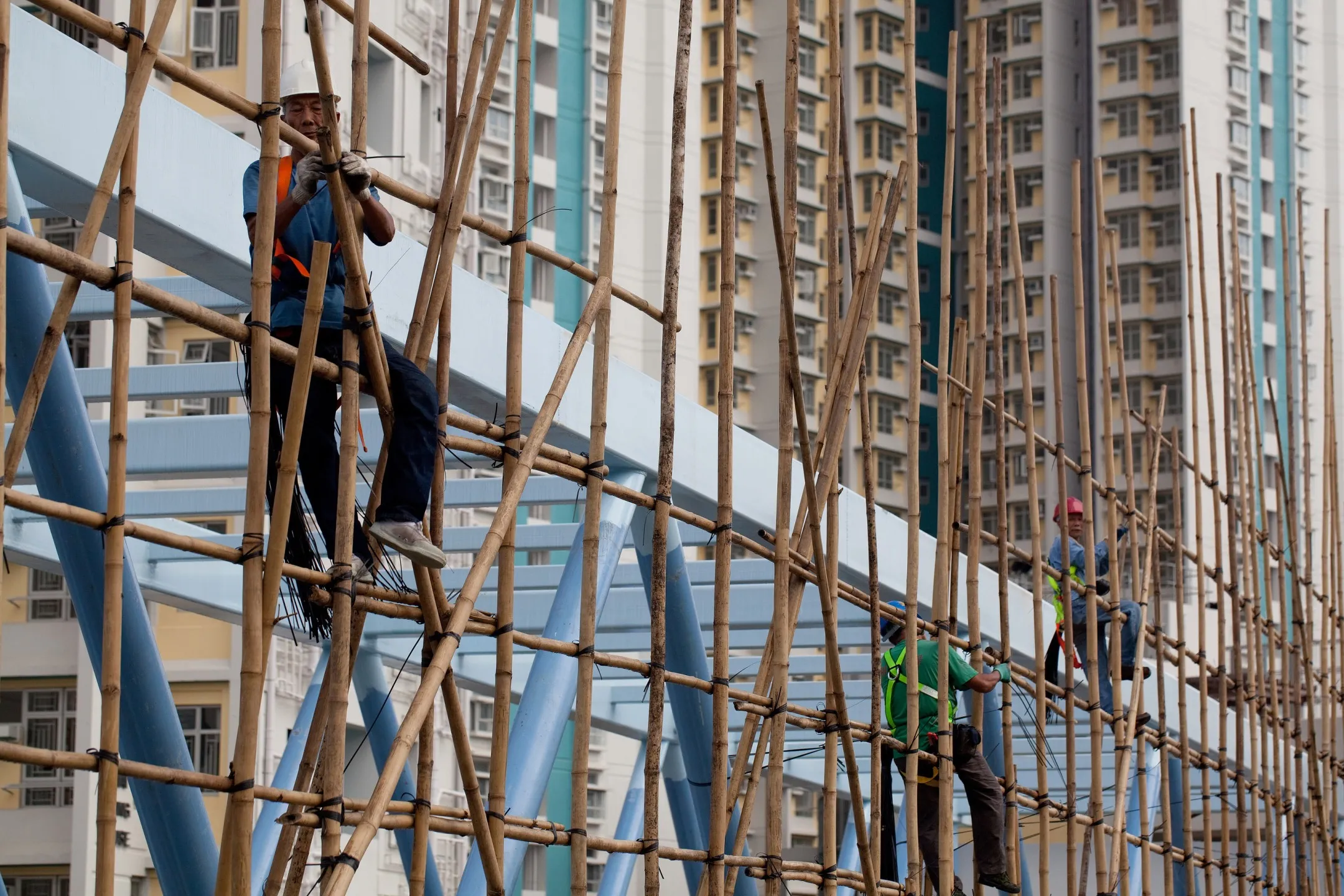 Workers erect bamboo scaffolding near residential tower blocks in Kowloon Bay.