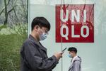 Pedestrians walk past a Uniqlo store, operated by Fast Retailing Co., in Shanghai, China