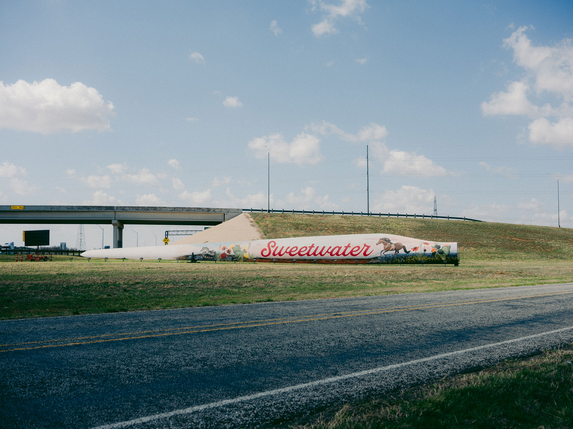 A sign from Global Fiberglass Solutions on State Highway 70 claims discarded wind turbine blades are being prepared for recycling in Sweetwater, Texas on March 6, 2026. Photographer: Brenda Bazán