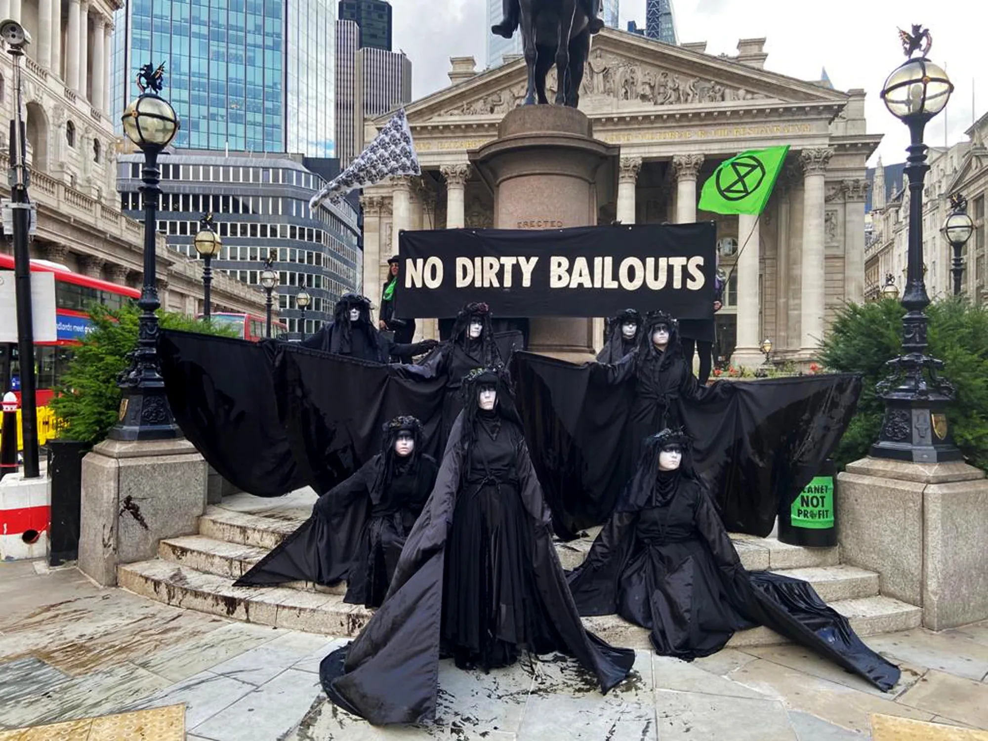 Protesters outside the Bank of England hold a banner that reads “No Dirty Bailouts on July 10.”