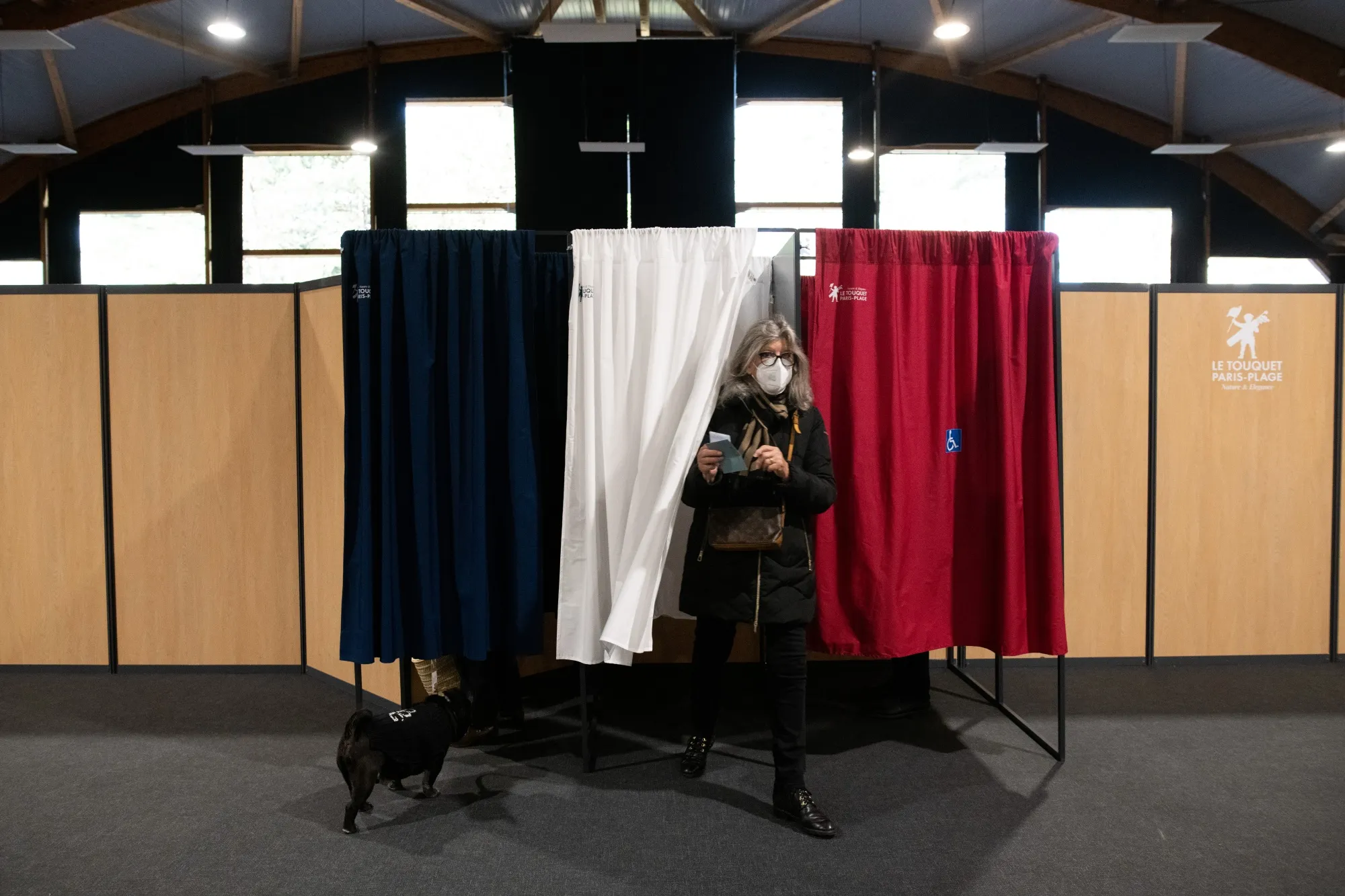 A voter exits a booth after marking her ballot in Le Touquet-paris, France, on April 10.