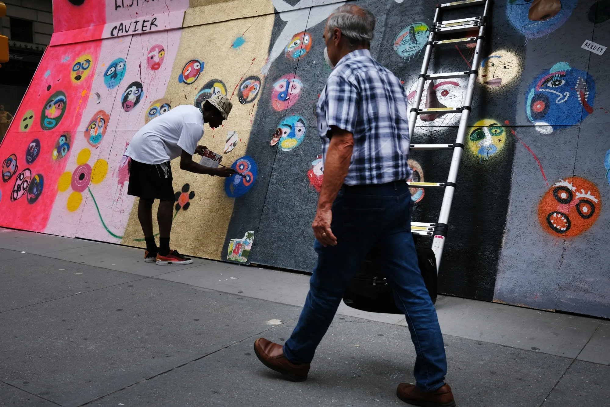 An artist who goes by the name Cavier paints over a boarded up Puma store in Manhattan in June 2020. As boards that covered storefronts are taken down, organizations are finding ways to reuse them, from preserving the public art to building food storage facilities.&nbsp;