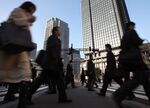 Morning commuters make their way to work in the central business district of Tokyo, Japan,