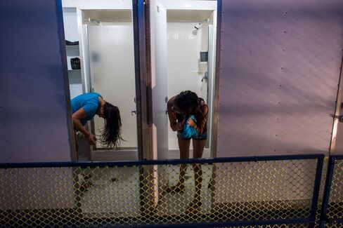 Two women dry their hair after taking showers at the portable showers available to use for free at the Iglesia Emmanuel Church in Porterville, Calif., on April 13, 2015. In a handful of drought-plagued communities, including Cambria, East Porterville and Santa Cruz, scarcity has forced changes. The communities face especially strict limits because they aren't part of the State Water Project, a system of canals and reservoirs that delivers mountain runoff to urban areas in the Bay Area and Southern California.