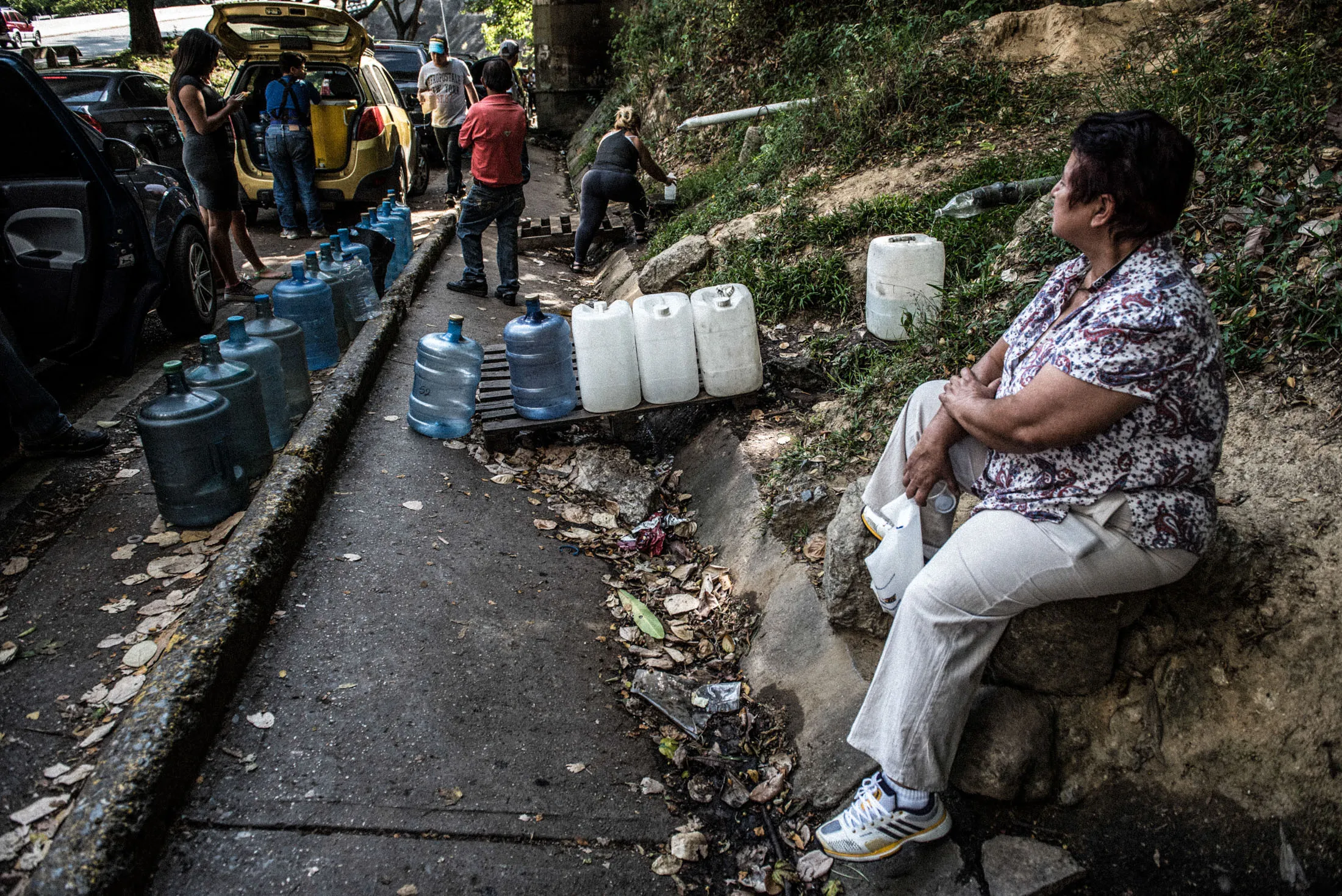 People wait to fill their bottles at a spring on the Waraira Repano mountain in Caracas last month.