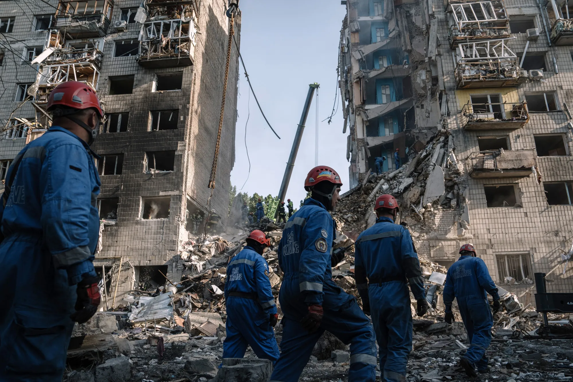 Rescue services search for victims under wreckage after an air strike on a residential building in Kyiv in June.