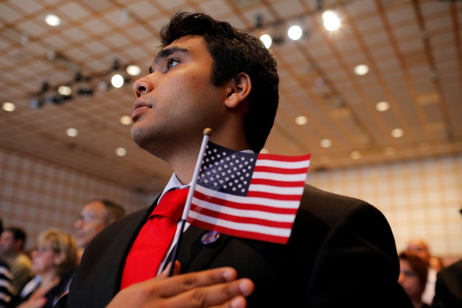 Stallone Laurel Dias, originally from India and a soldier in the U.S. Army, recites the U.S. Pledge of Allegiance after taking the oath to become a U.S. citizen during a ceremony in Boston, July 18, 2018.