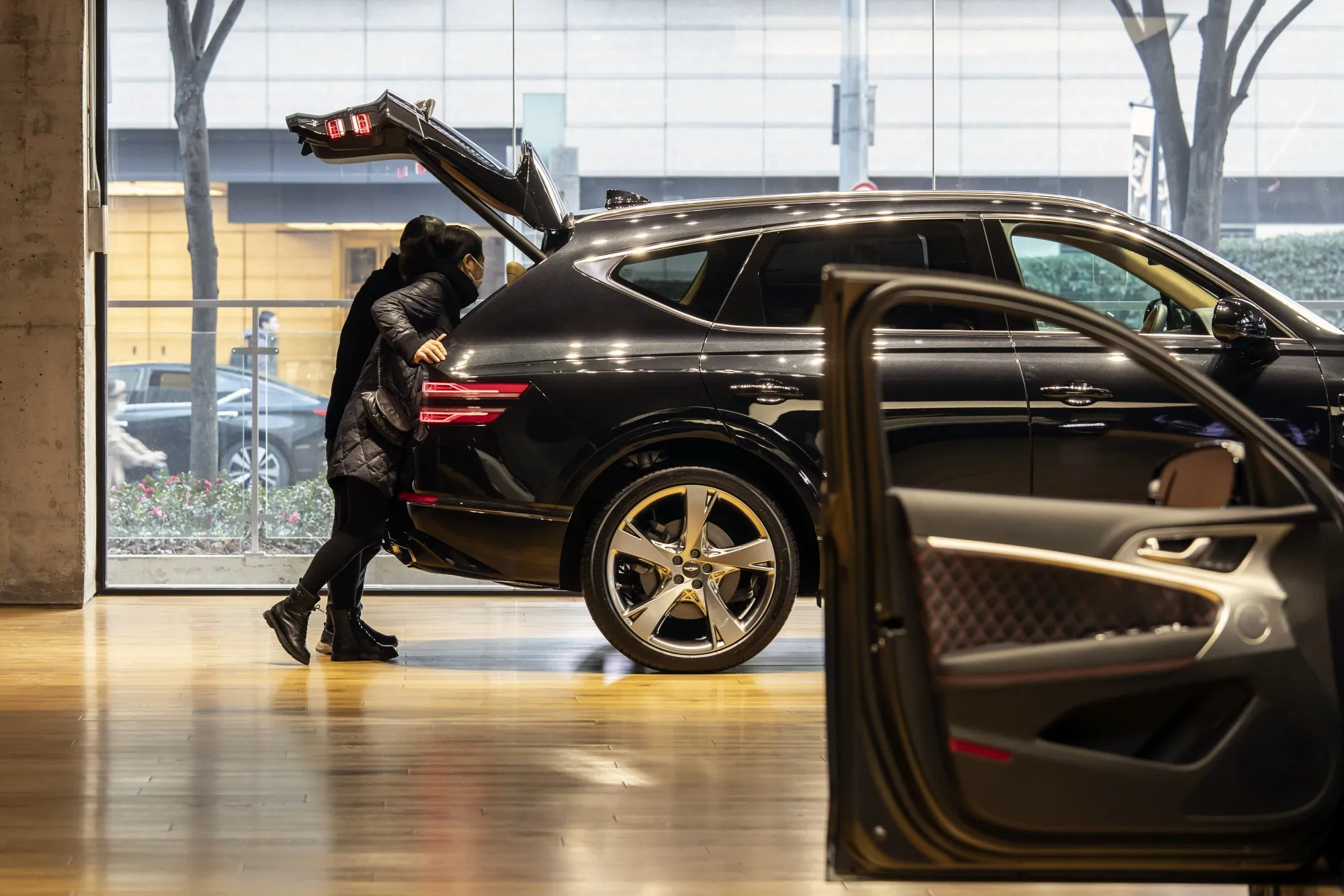 Customers browse a Hyundai Motor Co. Genesis GV80 crossover sport utility vehicle on display&nbsp;in Shanghai, China.