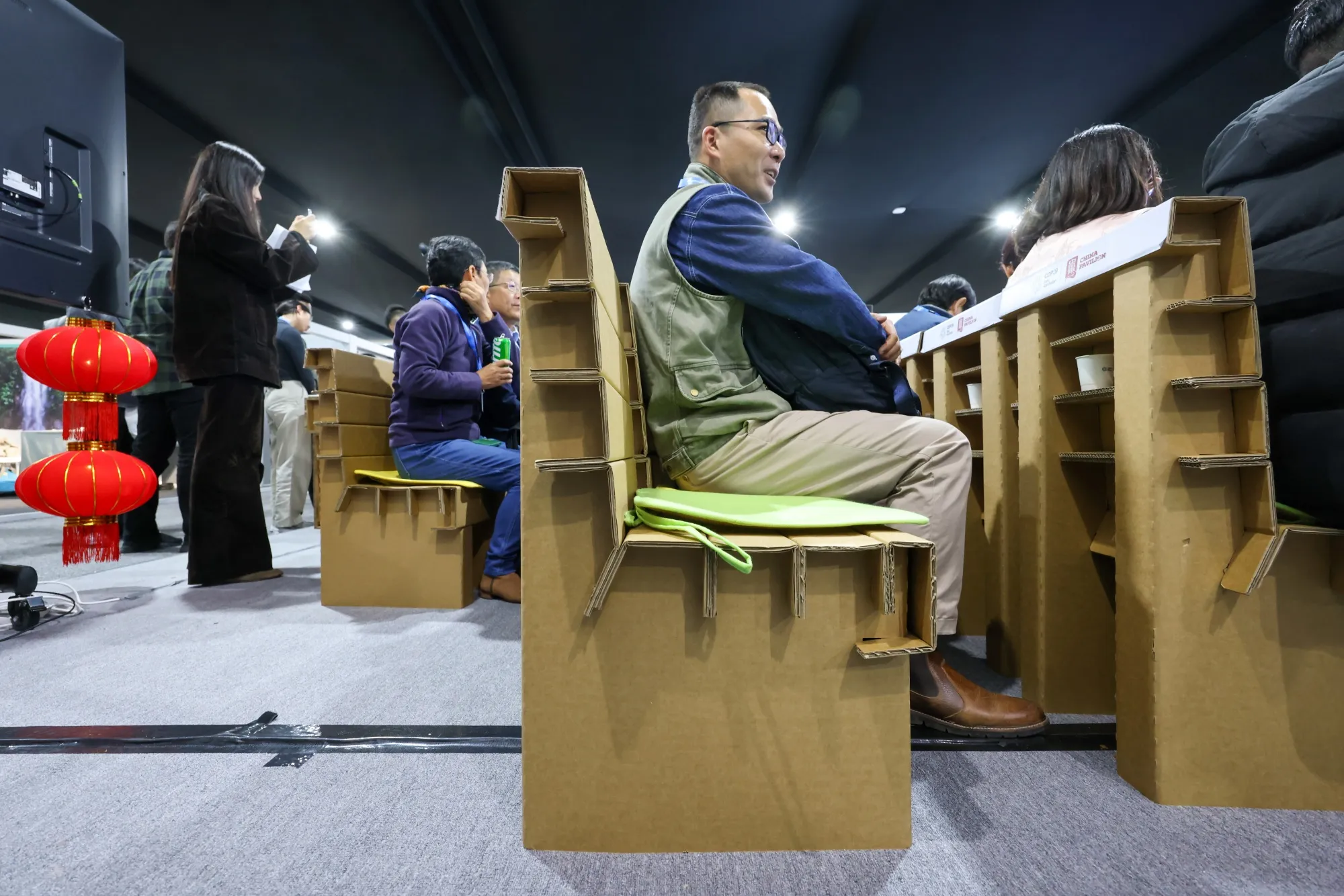Attendees sit on chairs made from carboard at the China pavilion during the COP29 climate conference in Baku, Azerbaijan, on Nov. 11, 2024. The United Nations climate change conference,&nbsp;COP29, runs through Nov. 22.