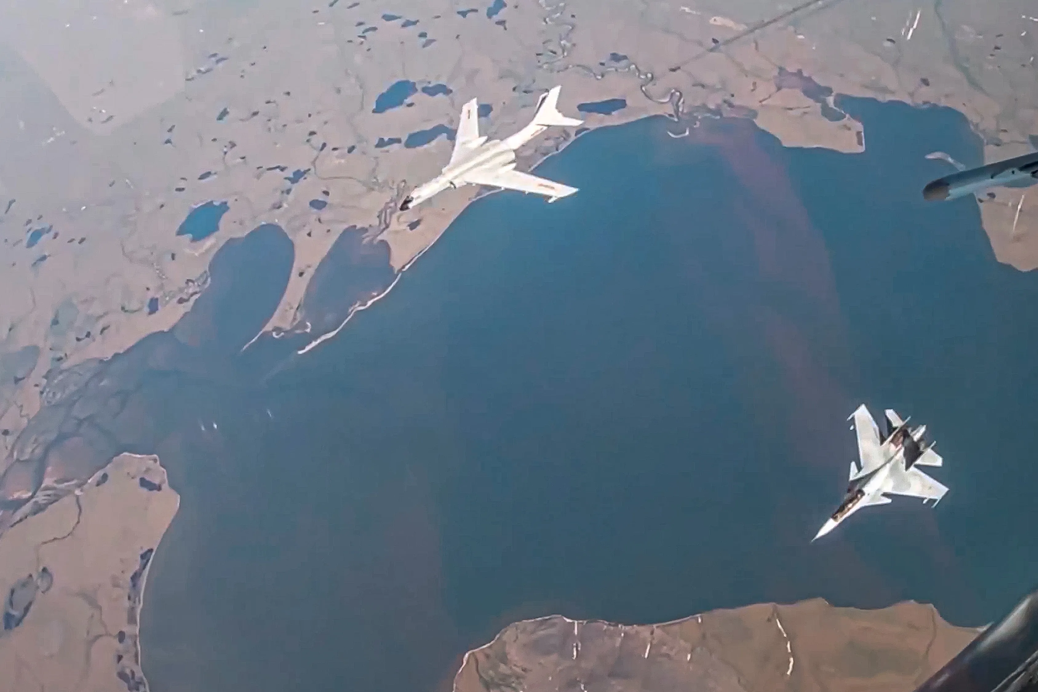 In this photograph distributed by the Russian Defense Ministry Press Service, a&nbsp;H-6K long-range bomber of the Chinese air force is seen escorted by a Su-30 fighter of the Russian air force.