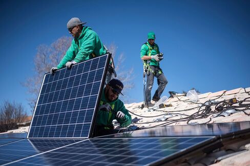 Workers secure solar panels to a rooftop during a SolarCity Corp. residential installation.