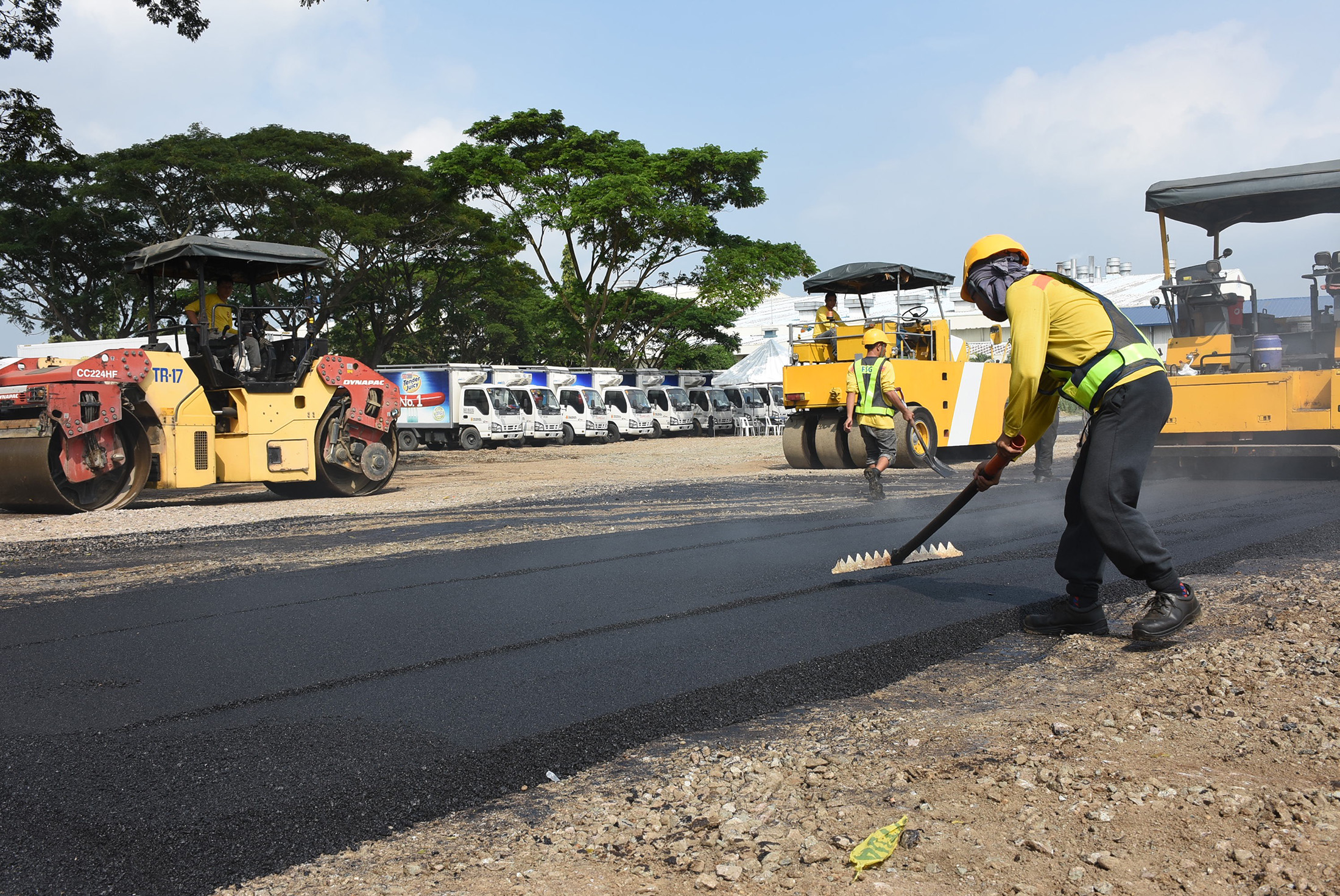 Workers lay a road made with asphalt and recycled plastics at a test site near Manila.