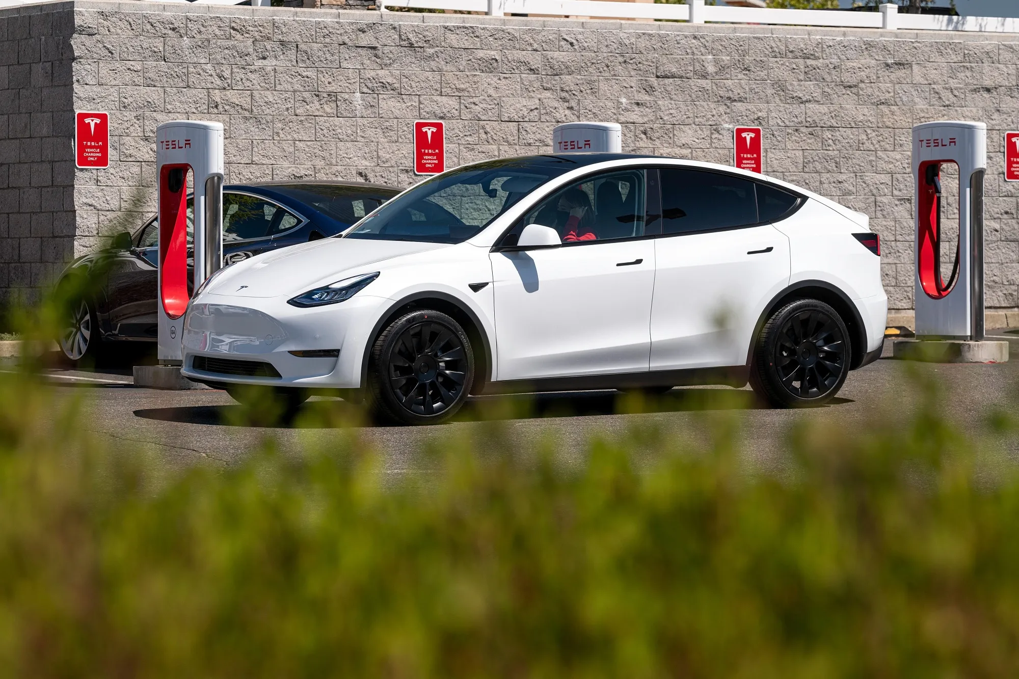 A Tesla vehicle&nbsp;drives past charging stations&nbsp;in Rocklin, California.