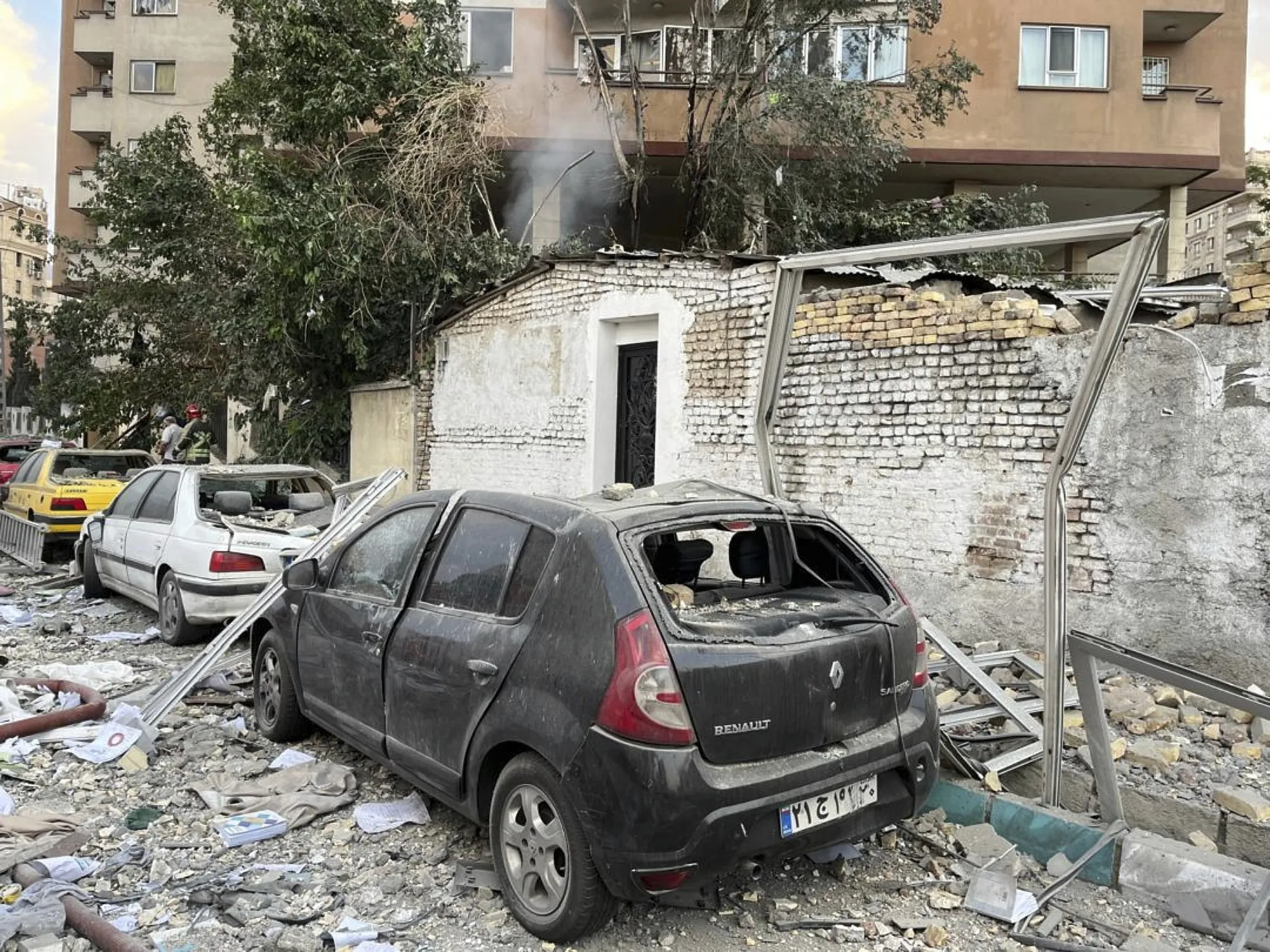 Debris from an apartment building is seen on top of parked cars after an Israeli airstrike in Tehran on Friday.