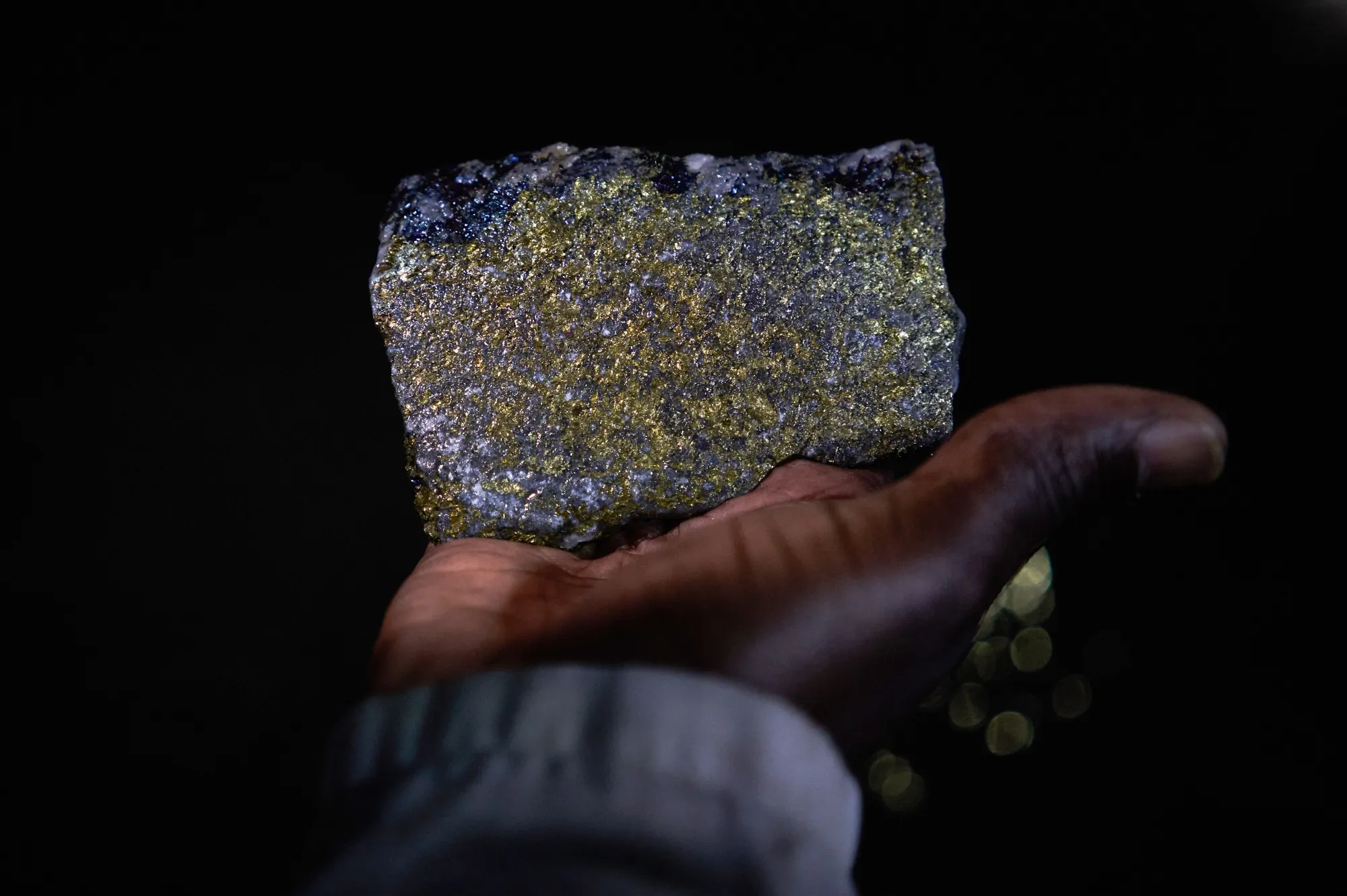 A worker holding a chunk of copper ore.