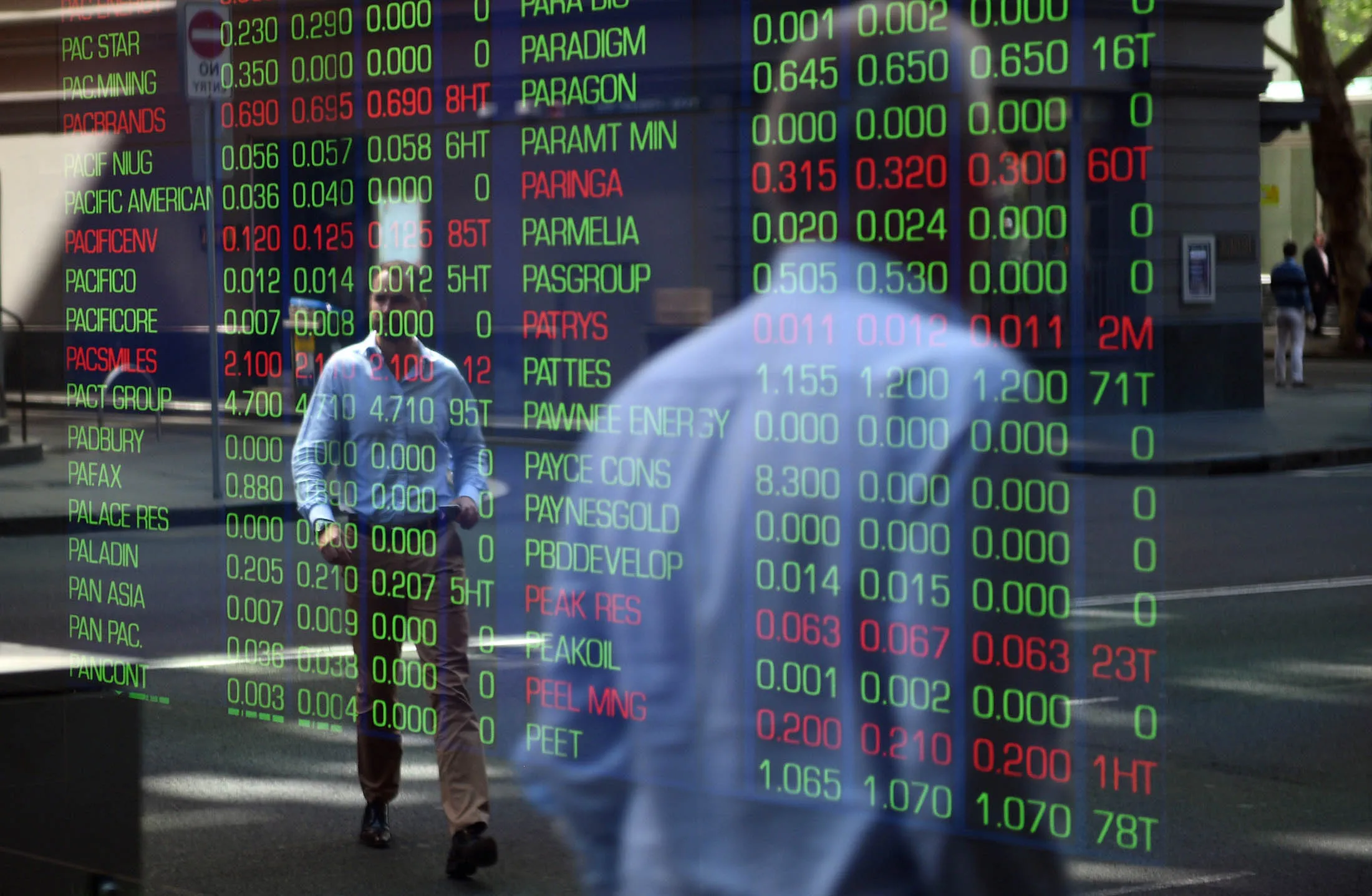 Passersby are reflected in the window of the Sydney Stock Exchange showing the benchmark S&amp;P/ASX200 index in Sydney on September 18, 2015. Australian stocks slipped 0.28 percent at the open after the US Federal Reserve left interest rates near zero overnight. AFP PHOTO / Peter PARKS (Photo credit should read PETER PARKS/AFP/Getty Images)

