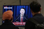 People watch Yoon Suk Yeol’s national televised address in Seoul, on Dec. 3.
