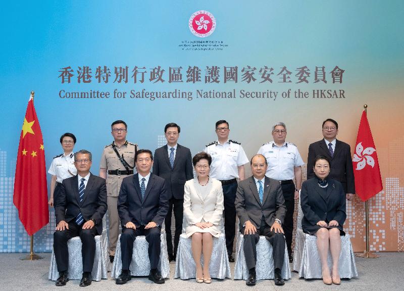 Chief Executive Carrie Lam, center, with Chris Tang, standing third from right, Au Ka-wang, standing second right, and Hermes Tang, standing second left, in July 2020.