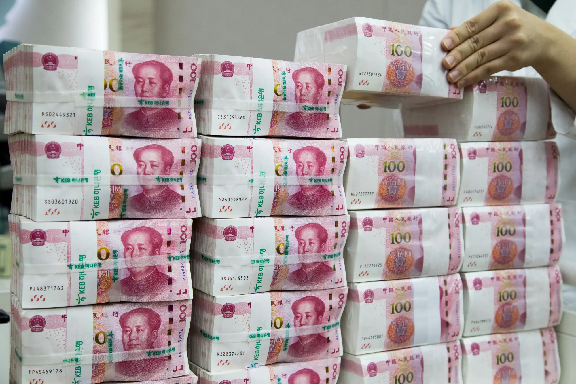 An employee arranges genuine bundles of Chinese one-hundred yuan banknotes at the Counterfeit Notes Response Center of KEB Hana Bank in Seoul, South Korea, on Monday, Aug. 14, 2017. China's factory output and investment slowed somewhat in July, according to data released today, yet the yuan appeared not to take the data as negative, if in fact it's paying attention to it at all.