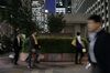 Pedestrians walk past signage for Mitsubishi UFJ Financial Group Inc. (MUFG) displayed outside the company's headquarters at night in Tokyo, Japan, on Friday, May 10, 2019. MUFG will announce its year-end earnings figures on on May 15.
