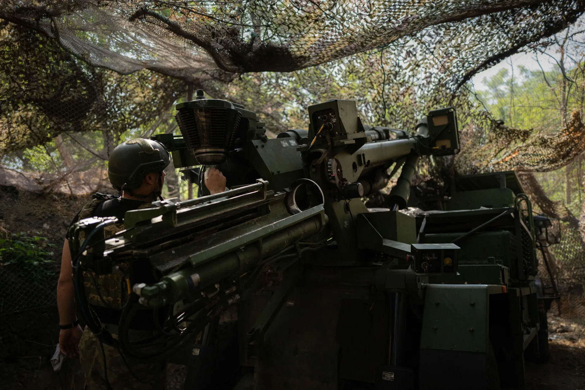 A Ukrainian soldier cleans the breech of a self-propelled gun near the eastern front line of Ukraine.