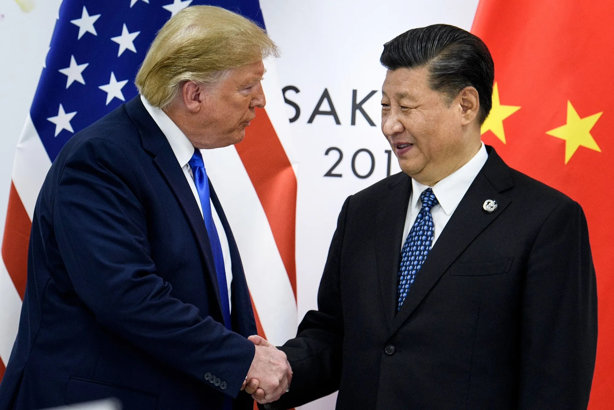 China's President Xi Jinping and US President Donald Trump shake hands prior to a meeting in Osaka in 2019.