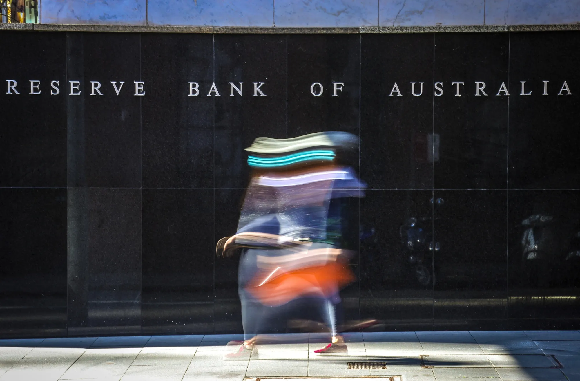 A pedestrian passes the Reserve Bank of Australia building in Sydney, Australia.