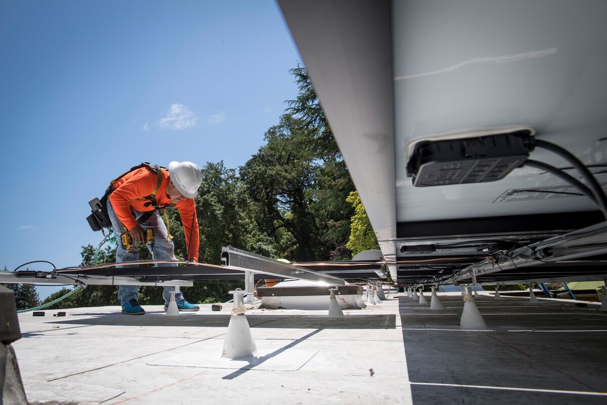 A worker installs a solar panel on a home in Lafayette, California in 2018. 