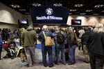 Attendees view Smith & Wessons Corp. firearms. 