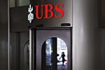 An illuminated sign hangs above the entrance to the UBS Group AG headquarters in Zurich.