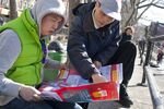 Ediwin Zheng, from CAAAV’s Chinatown Tenants Union, uses a CUP poster to do outreach in Chinatown’s Sara D. Roosevelt Park.