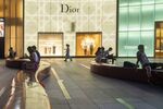 Visitors sit outside luxury stores on Orchard Road in Singapore.