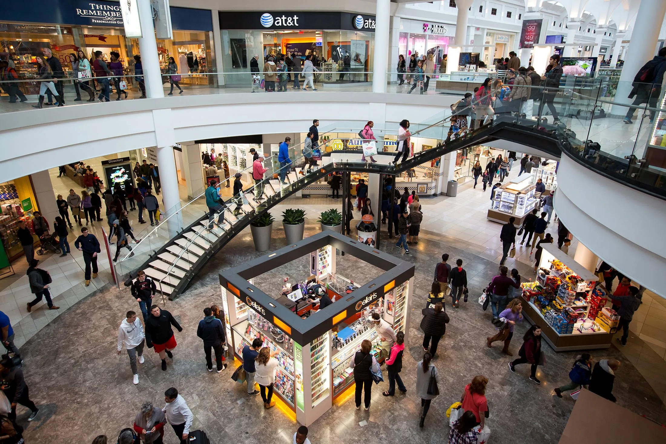 Shoppers walk through the Menlo Park Mall in Edison, New Jersey, U.S., on Friday, Nov. 25, 2016. As Black Friday ushers in the year-end shopping rush, chains are touting larger price cuts than in 2015 -- a gamble that maintaining market share is worth squeezing margins.

