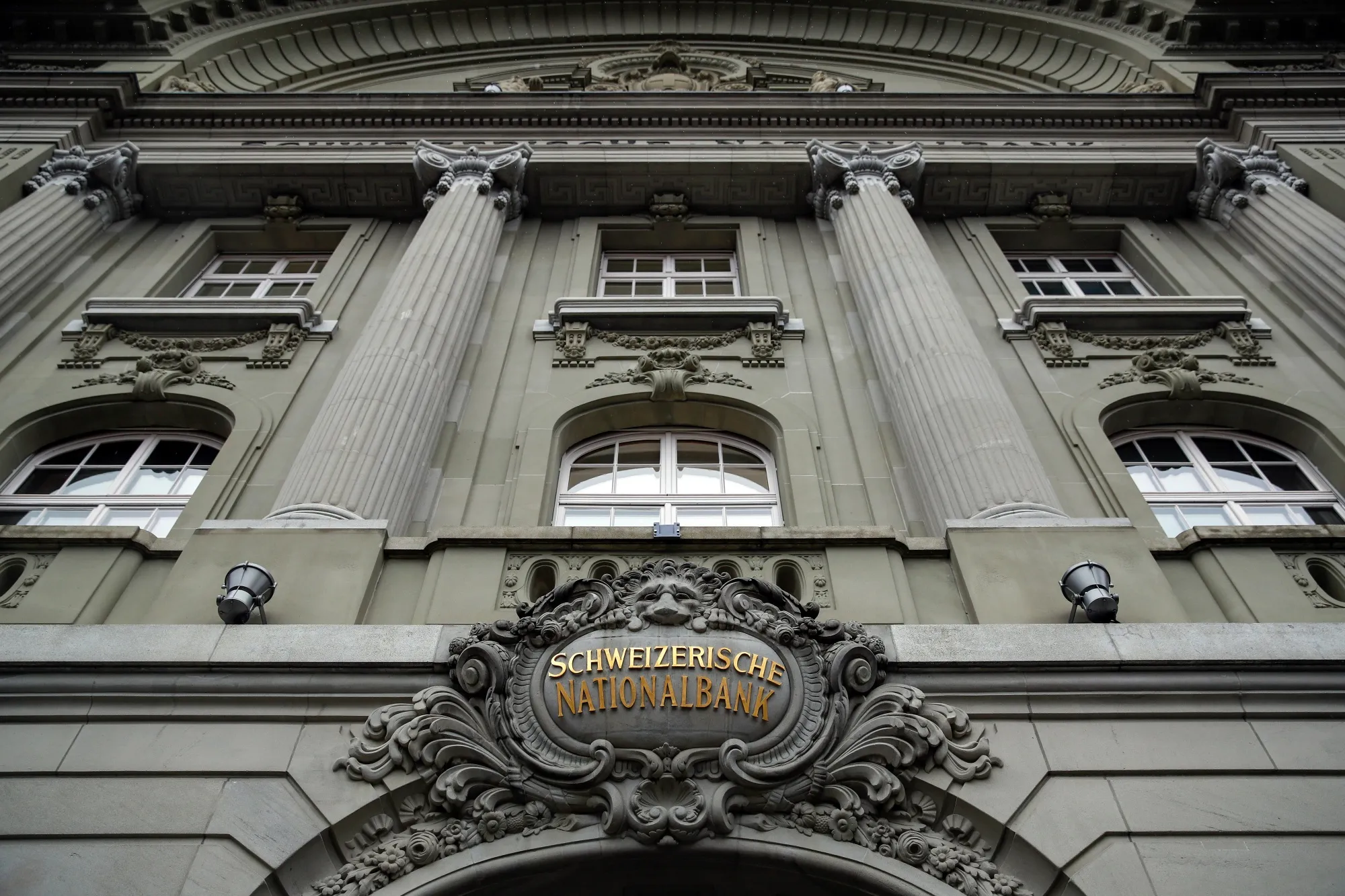 A Swiss National Bank (SNB) logo sits above the the entrance to the central bank in Bern, Switzerland.