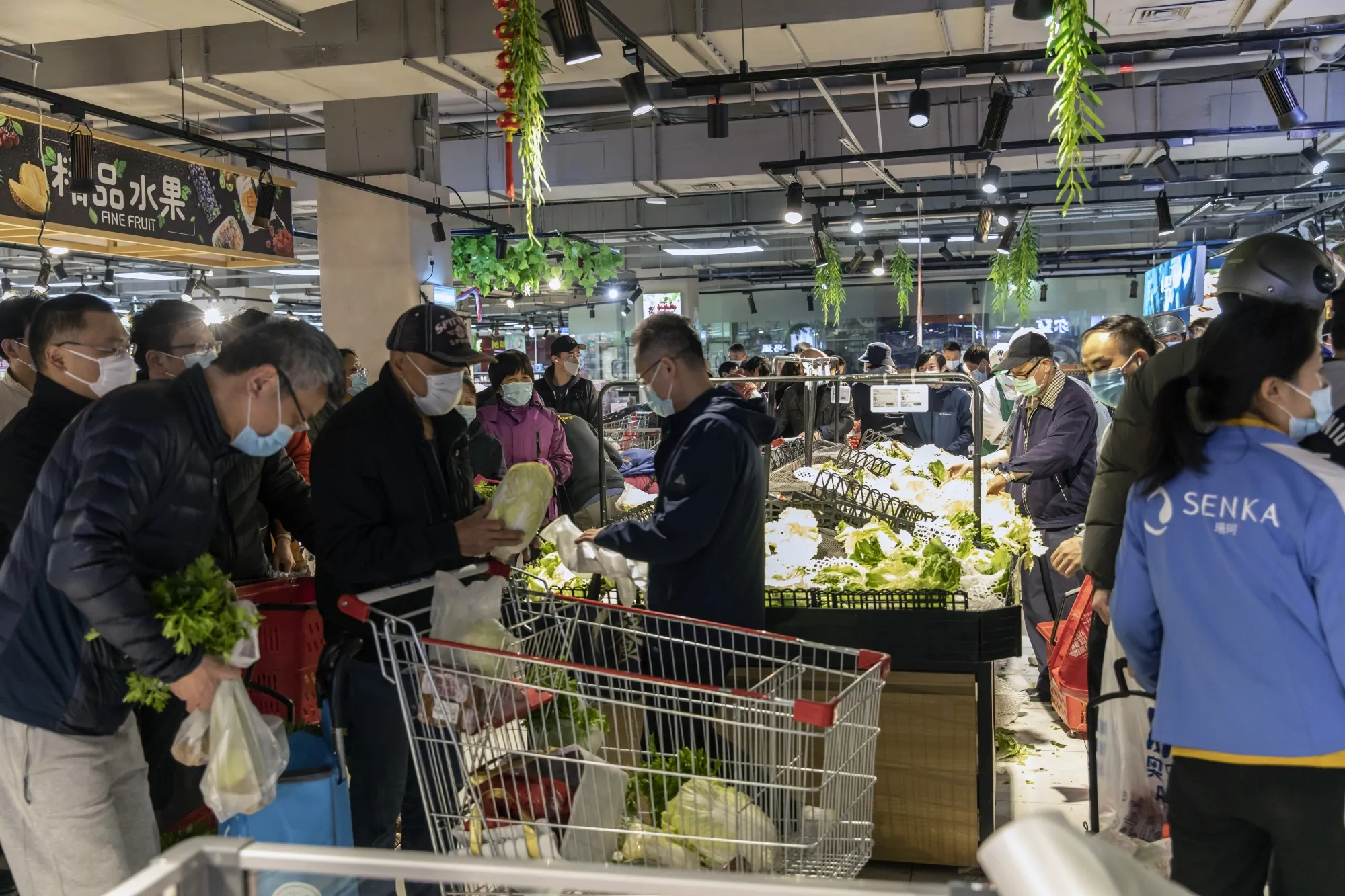 Customers purchase vegetables at a supermarket&nbsp;in Shanghai, China.