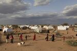 Somali refugees walk through an area housing new arrivals, on the outskirts of Hagadera Camp outside Dadaab, Kenya.