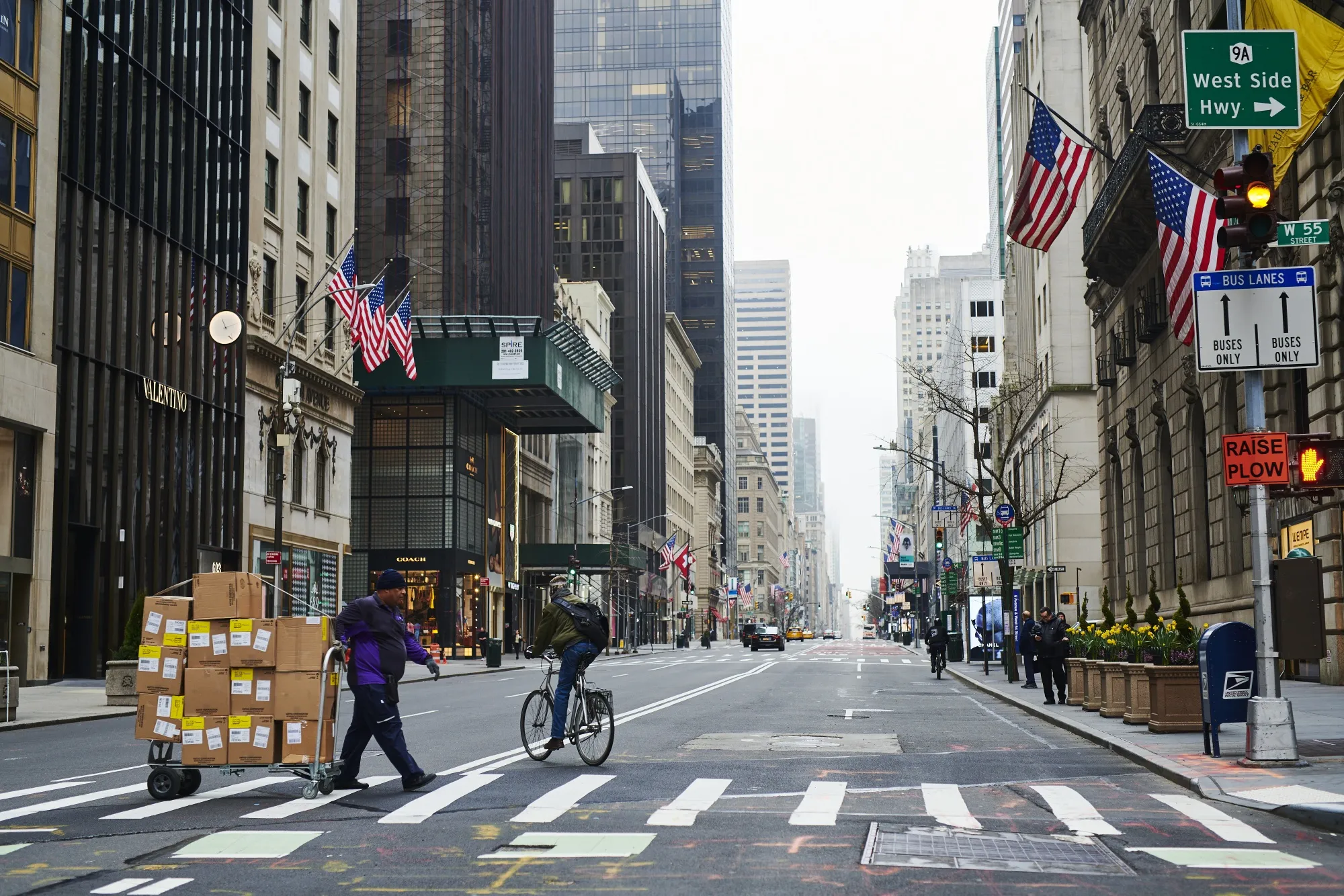 A worker pulls a trolley loaded with packages on 5th Avenue in New York.