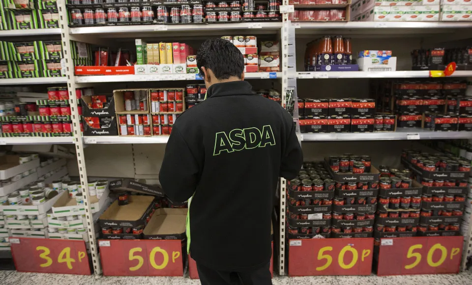An employee works at an&nbsp;Asda supermarket in Watford, U.K.