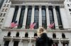American flags fly as a pedestrian walks past the New York Stock Exchange (NYSE) in New York, U.S.