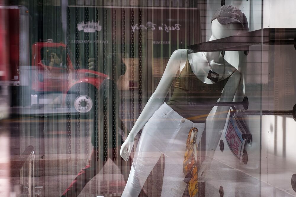 A mannequin leans against the wall inside a window display at an apparel store on State Street in Chicago, Illinois, U.S., on Friday, June 5, 2020. =